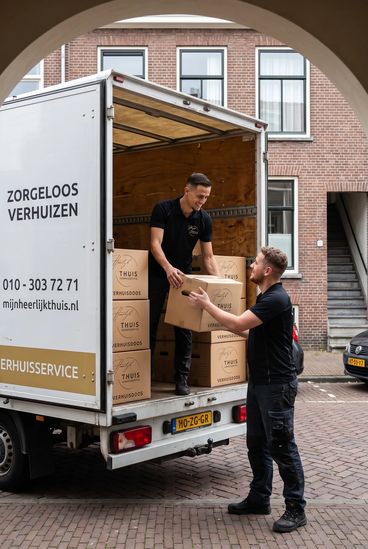 Verhuizer van Heerlijk Thuis neemt een verhuisdoos aan in de laadbak van de verhuiswagen